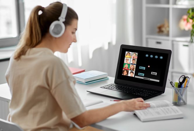 education, school and distant learning concept - female teacher in headphones with laptop computer and book having online class with little students at home